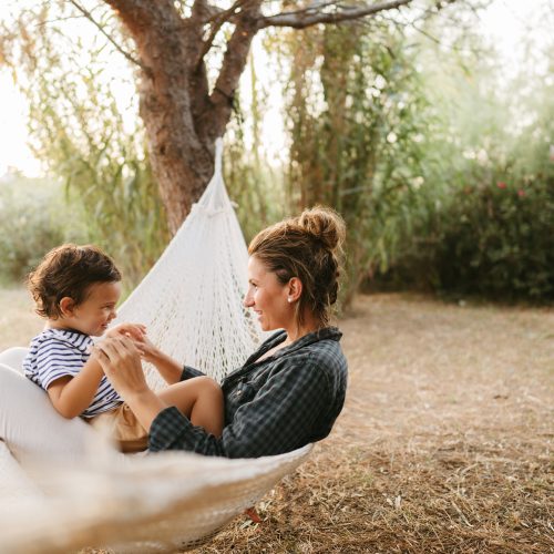 Photo of a little boy and his mother having a relaxing moment in a hammock